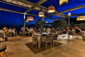 ein Restaurant mit Leuten, die nachts an Tischen sitzen in der Unterkunft Hotel Riva by Aycon in Petrovac na Moru