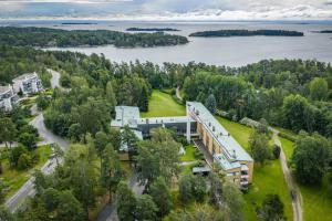 an aerial view of a building with a lake in the background at Hotel Jollasranta Helsinki in Helsinki