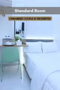 una camera da letto con un letto e una scrivania di Laswi Syariah Guest House a Bandung