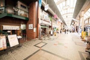 an empty shopping mall with people walking through it at マエカワビル403Private In-Room Theater in Osaka