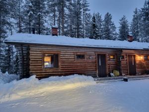 a log cabin in the snow with snow around it at Log cabin Ylläs Valokki - sauna, fireplace, Ylläs view in Ylläsjärvi