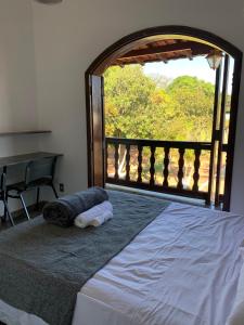 una camera con un letto e una finestra aperta di Pousada Flat Royal Suíte com varanda e rede a Itapecerica