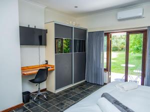 a bedroom with a bed and a desk and a chair at House 1967 in George
