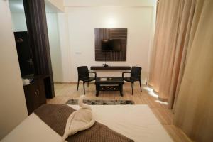 a living room with a table and chairs and a television at Exotic resort in Gaushala