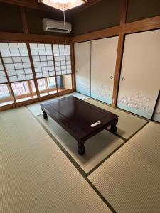 a ping pong table in a room with windows at ゲストハウス輪 高野山麓 in Hashimoto