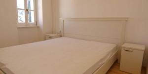a bedroom with a white bed and a window at Mariana B4 in Veli Lošinj
