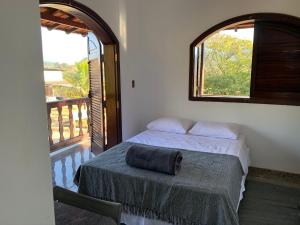 una camera da letto con un letto e una grande finestra di Pousada Flat Royal Suíte com varanda e rede a Itapecerica