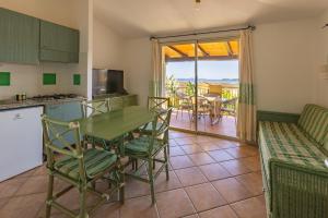 a kitchen and living room with a table and chairs at Residence Le Bouganville in Villasimius