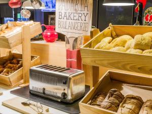 eine Bäckerei, auf deren Tisch ein Toaster und Schachteln mit Gebäck stehen. in der Unterkunft Hotel Ibis Lisboa Sintra in Sintra + 69 Fotos