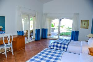 Un dormitorio con una cama y un escritorio y una ventana. en Rooms and villas in Sheraton Sharm el Sheikh, en Sharm El Sheikh