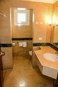 Un baño con lavabo, inodoro y ventana. en Rooms and villas in Sheraton Sharm el Sheikh, en Sharm El Sheikh