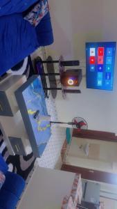 a room with a bed with a desk and a shelf with a bed at Kash apartments in Diani Beach