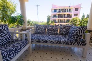 a bench on a balcony with zebra pillows at Kash apartments in Diani Beach +2 photos