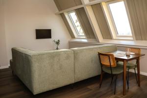 Zicht op Urk في أورك: غرفة معيشة بها أريكة وطاولة