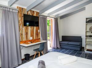 a bedroom with a bed and a desk and a couch at House 1967 in George