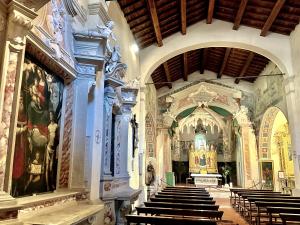 a church with pews and paintings on the walls at Casa Giovanna in Montemerano +22 photos