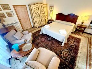 a bedroom with a bed and chairs and a table at Casa Giovanna in Montemerano