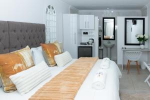 ein Schlafzimmer mit einem großen weißen Bett und ein Badezimmer in der Unterkunft Relmies Place in Modimolle