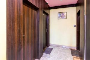 a hallway with wooden doors and a tile floor at Hotel O Mahal in Durgāpur