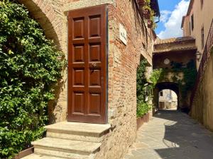 a brown door on the side of a brick building at Casa Giovanna in Montemerano