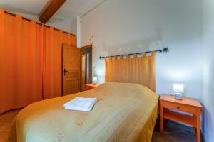 a bedroom with a bed and two tables and a window at Joli gîte avec piscine in Laval-Saint-Roman +16 photos