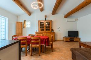 a dining room with a table and a tv at Joli gîte avec piscine in Laval-Saint-Roman