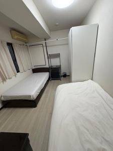 東京にあるTokyo Kakanのベッド2台と冷蔵庫が備わる客室です。