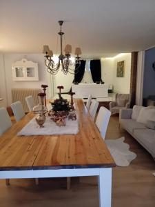 a dining room with a wooden table and white chairs at Meteora Grande luxury suite & spa villa in Kalabaka