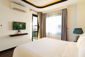a bedroom with a white bed and a window at Lantern Boutique Hoi An in Hoi An +50 photos