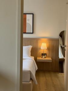 a bedroom with a bed and a table with a lamp at Wora Phuket in Ban Sam Kong