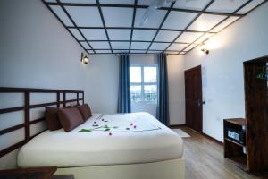 ماديفارو كرو في جزيرة راسدو: غرفة نوم بها سرير أبيض كبير مزين بالزهور