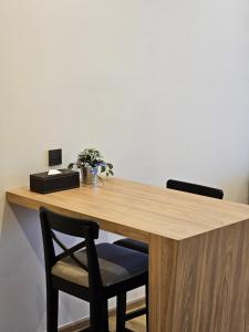 a wooden desk with two chairs in a room at Wora Phuket in Ban Sam Kong