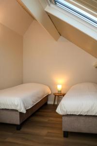 Zicht op Urk في أورك: سريرين في غرفة بها نافذة