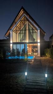a large glass house with lights in front of it at Pai Prestige - Luxury Pool Villas in the centre of Pai in Pai