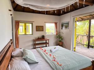 a bedroom with a bed in a room with a window at Casa Hwinzo at Hwinzo Retreat, Tofo in Praia do Tofo