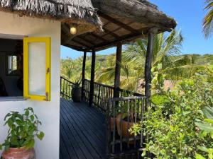 a porch of a house with a yellow door at Casa Hwinzo at Hwinzo Retreat, Tofo in Praia do Tofo