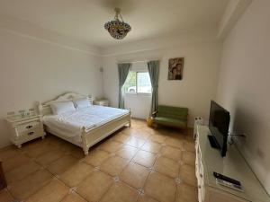 a bedroom with a bed and a flat screen tv at Amei's Home in Dayin