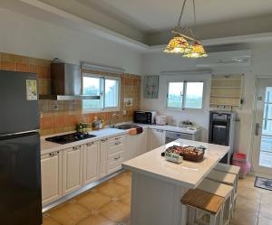 a kitchen with white cabinets and a black refrigerator at Amei's Home in Dayin