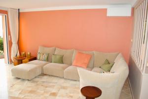 Villa Capdale Horizon with separate guest house في كاب دايل: غرفة معيشة مع أريكة وجدار برتقالي +60 صورة