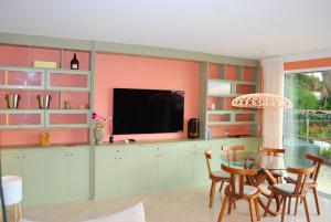 Villa Capdale Horizon with separate guest house في كاب دايل: غرفة طعام مع طاولة وتلفزيون