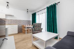 米泽德沃兹Little Laguna Apartments SPA & Gym by Noclegi Renters的客厅里有一张沙发和一张桌子。 更多67张照片