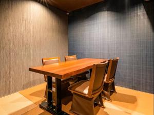 a conference room with a wooden table and chairs at 割烹旅館 清都 in Hongō