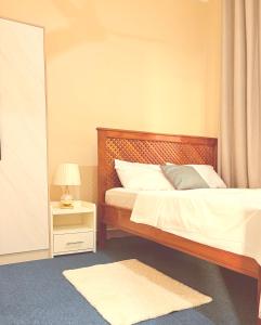 a bedroom with a bed and a night stand with a lamp at Blesauz Apartments in Dar es Salaam