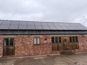 a building with solar panels on top of it at New House Barn in Ashbourne +13 photos