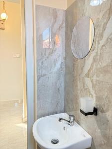 a bathroom with a sink and a mirror at Blesauz Apartments in Dar es Salaam