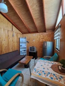 een woonkamer met een bank en een tafel bij Cabañas Armerillo in Colbún Alto