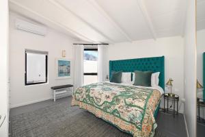 a bedroom with a large bed with a green headboard at No. 6 The Yard in Franschhoek