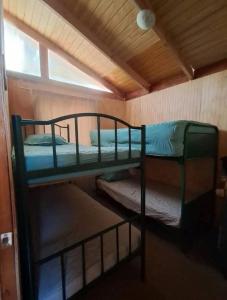 twee stapelbedden in een kamer met een raam bij Cabañas Armerillo in Colbún Alto