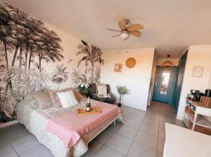 a bedroom with a bed with a table on it at Appartement Coup de Coeur avec Parking et Piscine - 131 in Canet-en-Roussillon