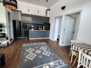 a kitchen with a table and a black refrigerator at T38 Apartment, Vatra Dornei in Vatra Dornei +1 photo